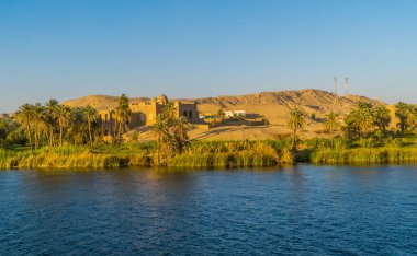 Mısır 'ın Luxor yakınlarındaki Nil Nehri üzerinde geleneksel bir kasaba manzarası