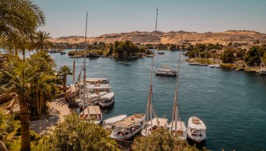 Aswan, Mısır - 2 Nisan 2021 - Nil 'deki botların panoramik görüntüsü arka planda fil adasıyla Eski Katarakt Oteli' nden görüldü