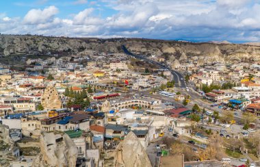 Goreme, Türkiye - 20 Mart 2021 - Kapadokya 'daki Goreme kasabasının panoramik manzarası, peri bacaları, evleri ve benzersiz kaya oluşumları