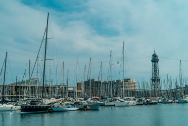 Barselona, İspanya - 15 Nisan 2021 - Barcelona limanında arka planda teleferikli yelkenli ve motorlu tekne panoramik görüntüsü