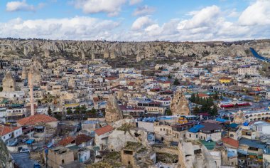 Goreme, Türkiye - 20 Mart 2020 - Türkiye 'nin Kapadokya kentindeki Goreme kasabasının güzel panoramik manzarası. Peri bacaları, evleri, camileri ve eşsiz kaya oluşumları var.