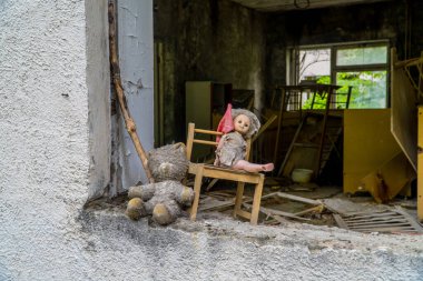 Horror-film like doll and teddy bear in an abandoned kindergarten in Pripyat, Ukraine inside the Chernobyl Exclusion Zone clipart