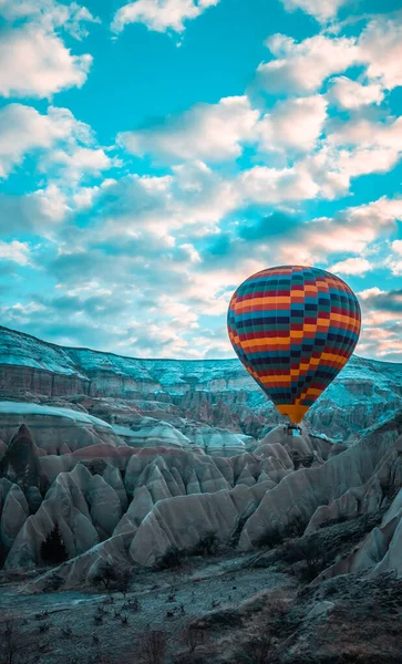 典型岩层日出时在土耳其卡帕多西亚飞行的热气球的垂直视图 — 图库照片