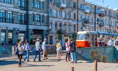 Podil, Kyiv, Ukrayna - 16 Haziran 2021 - Yolcuların sokak fotoğrafları ve geleneksel binalı klasik kırmızı tramvay