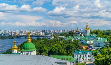 Kyiv, Ukrayna - 7 Haziran 2021 - Pechersk Lavra altın kaplama Ortodoks kiliseleri ve, Dinyeper nehri ve arka plandaki sosyalist yerleşim blokları panoramik görünümü