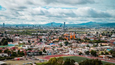 Cholula, Puebla, Meksika - 29 Ağustos 2021 - Bulutlu bir günde Cholula Piramidi 'nden Puebla ve Cholula şehirlerinin panoramik hava manzarası