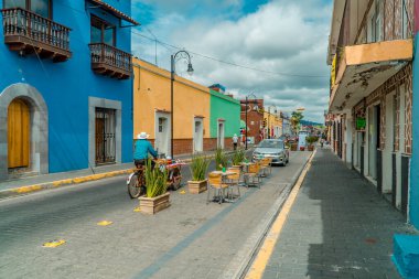 Cholula, Meksika - 29 Ağustos 2021 - Cholula 'nın Pueblo büyücülüğünde sömürge mimarisi olan bisikletli satıcı