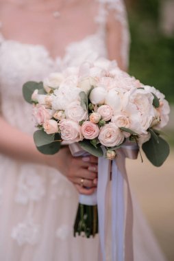Düğün buketi tutan gelinin yakın plan görüntüsü. pembe ve beyaz güller