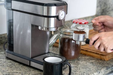 Evde kahve makinesiyle kahve yapmak filtredeki kahveye bastırmak.