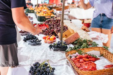 Yerel bit pazarından bir kutu vişneli domates alan tanınmamış bir adam.