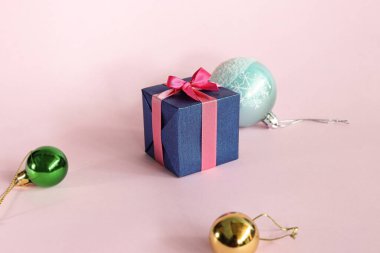 Özel tatil için açık pembe arka planda mavi hediye kutusu.