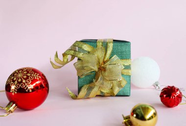 Yeşil hediye kutusu ve Pembe arka planda Altın fiyonk.