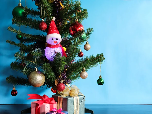 Suni Noel ağacının bir parçasıyla parlayan hafif kardan adam bebeği..