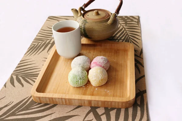 Daifuku Mochi ve yeşil çay, tahta tepsiye koyun. Yakınlarda bir çaydanlık var. Geleneksel bir Japon şekerlemesi..