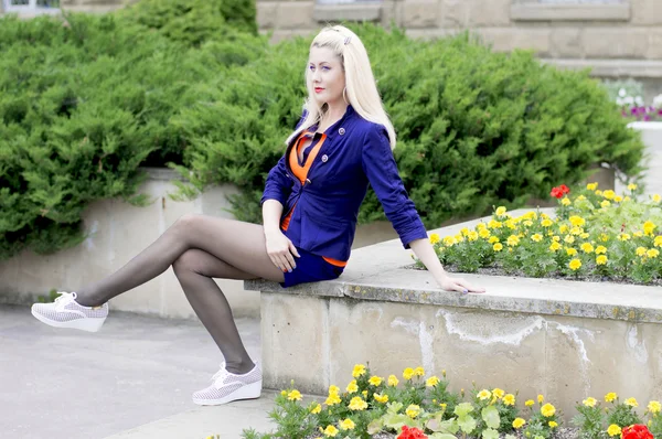 The beautiful woman sits at a flower lawn — Stock Photo, Image