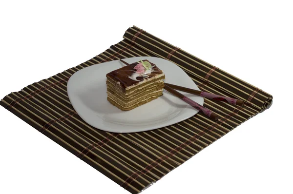 Braune Torte auf weißem Teller, auf weißem Hintergrund mit Teppich — Stockfoto
