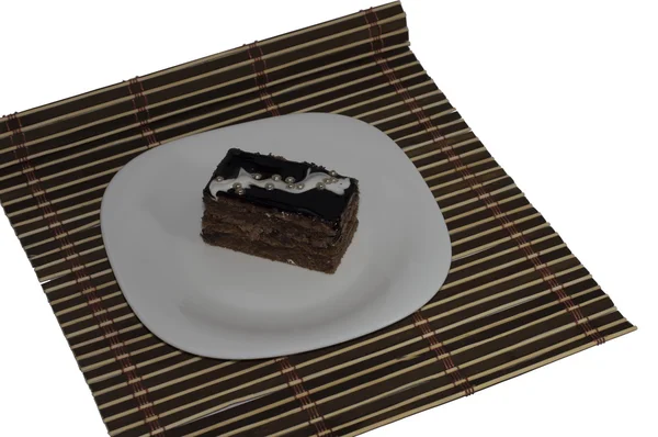 Brown Cake With Pearls On A White Plate, On A Brown Rug — Stock Photo, Image