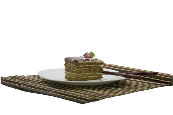 Beige Torte auf weißem Teller, auf Teppich, mit Essstäbchen — Stockfoto