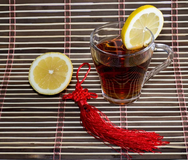 Glass of tea on a rug with a lemon — Stock Photo, Image