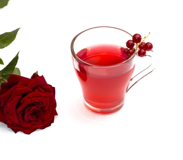 Стакан сока, смородины и цветка красной розы — стоковое фото