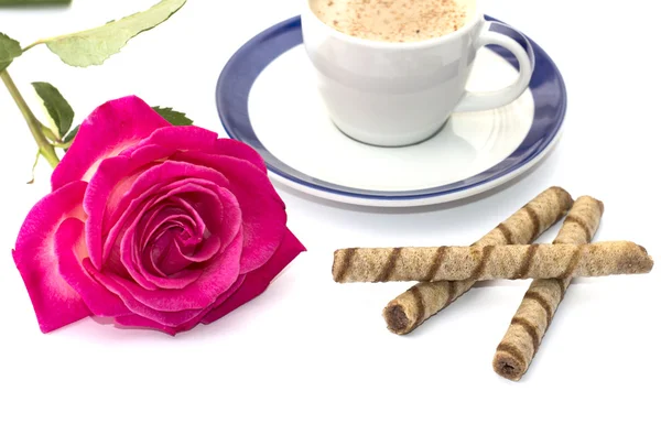 A caneca de um cappuccino e a flor de uma rosa fecham — Fotografia de Stock