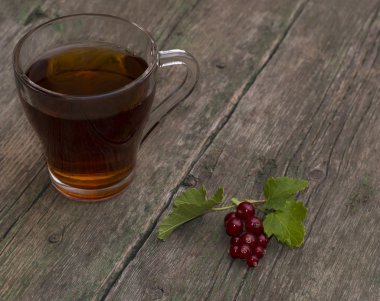 şeffaf bardak çay ve eski püskü masaüstünde Frenk üzümü