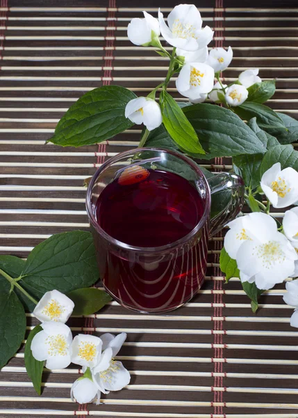 La tasse transparente de boisson rouge décorée d'une fleur — Photo