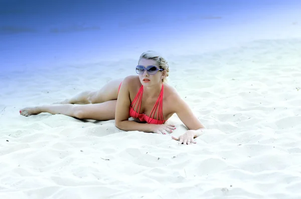 Красивая блондинка на белоснежном песке в лиловом тени — стоковое фото