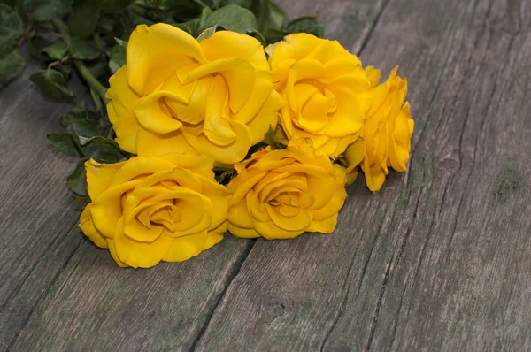 Красивий букет з жовтих троянд на дерев'яному шерстяному столі — стокове фото