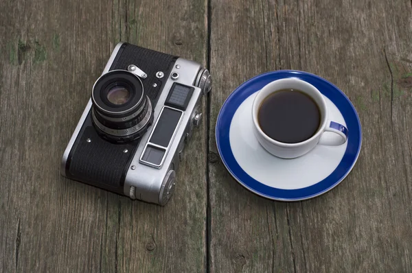 Retro kameran och en kopp svart kaffe på ett bord — Stockfoto