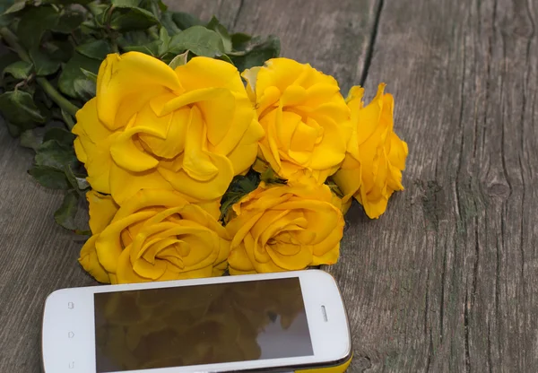 Bouquet of yellow roses and their reflection in the phone — Stock Photo, Image