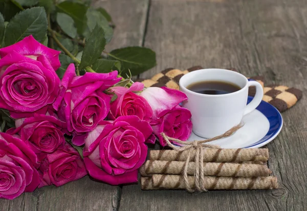 Fincan kahve, kurabiye ve kırmızı kırmızı gül buketi