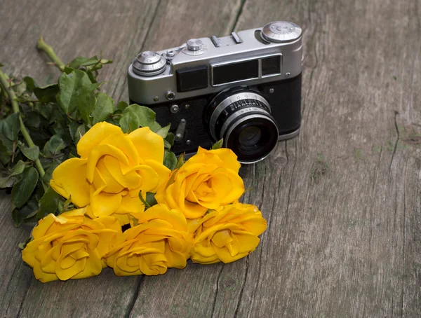 Yellow roses and retro the camera behind them on a table
