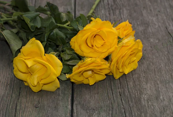 Beautiful bouquet of yellow roses on a wooden table — Stock Photo, Image