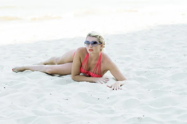 Красива жінка в помаранчевих Bikin лежить на піску — стокове фото