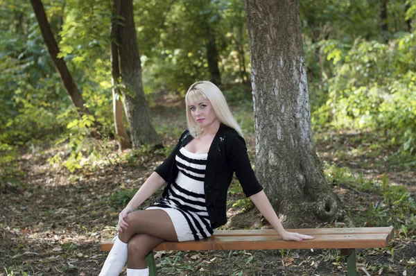 güzel kadın sonbahar parkta bir bankta oturur