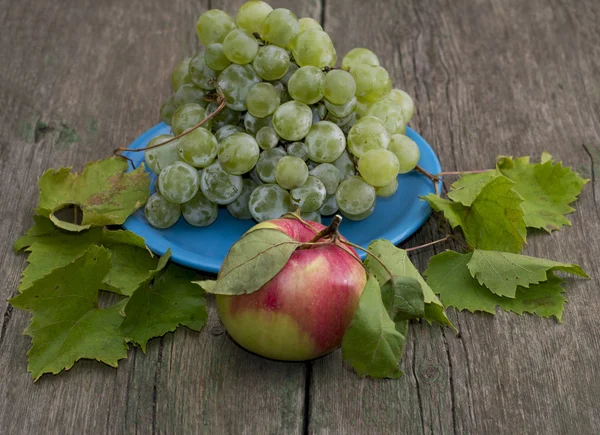 Натюрморт тарілка з виноградом і одне яблуко в центрі, є d — стокове фото