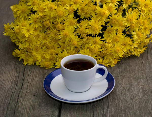 fincan kahve ve güzel buket çiçek, ahşap tabl üzerinde