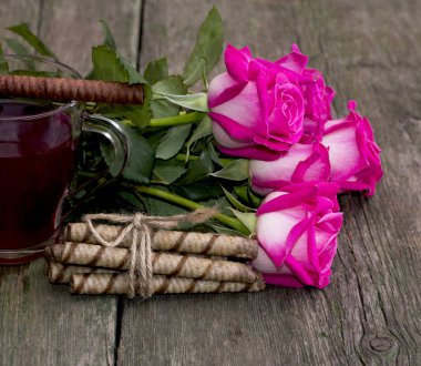 bouquet of roses, baking and fragment of a cup of tea