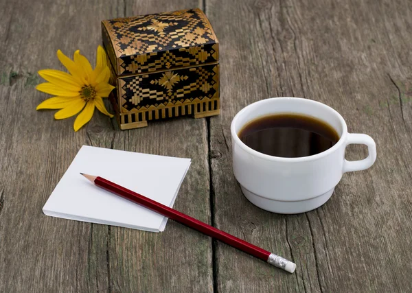 Гроб, кофе, карандаш с бумагой и желтый цветок — стоковое фото
