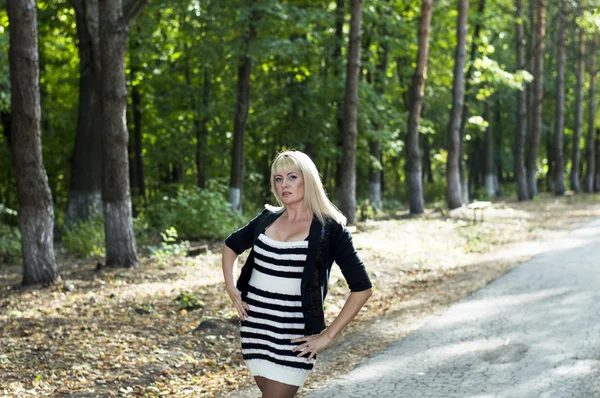 The beautiful woman the blonde walks in park — Stock Photo, Image