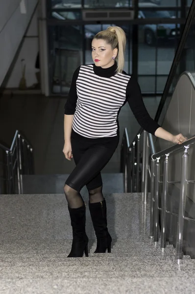De mooie vrouw stijgt op trappen van shopping center — Stockfoto
