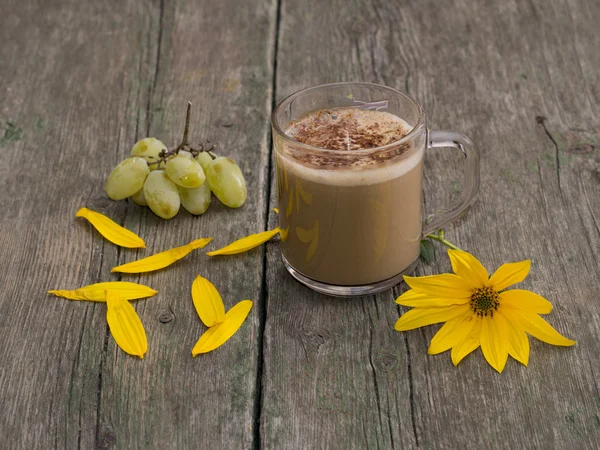 Sarı bir çiçek ve üzüm ile dekore edilmiş kapuçino Kupası 