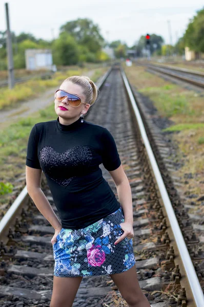 De aantrekkelijke vrouw tegen het spoorlijnen — Stockfoto