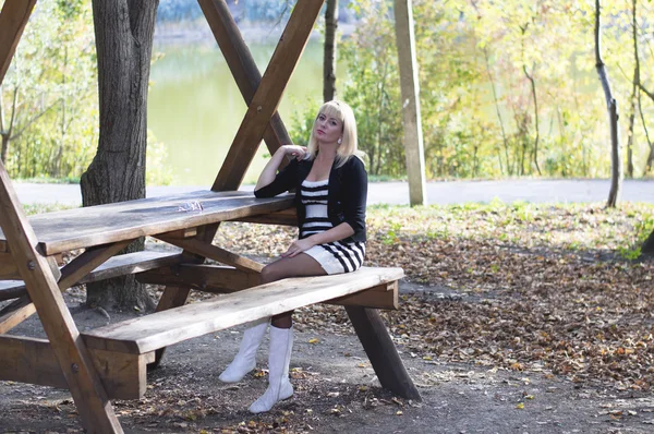 在湖边的一张木桌旁的年轻女孩 — 图库照片
