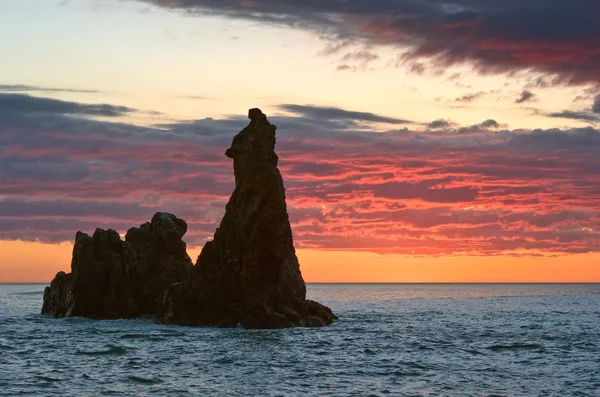 Eenzame rots in de zee bij zonsopgang. — Stockfoto