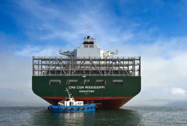 Nakhodka. Rusya - 17 Eylül 2015: Bir büyük konteyner gemisi stern adlı küçük bir römorkör Cma Cgm Mississippi koyda demirli.