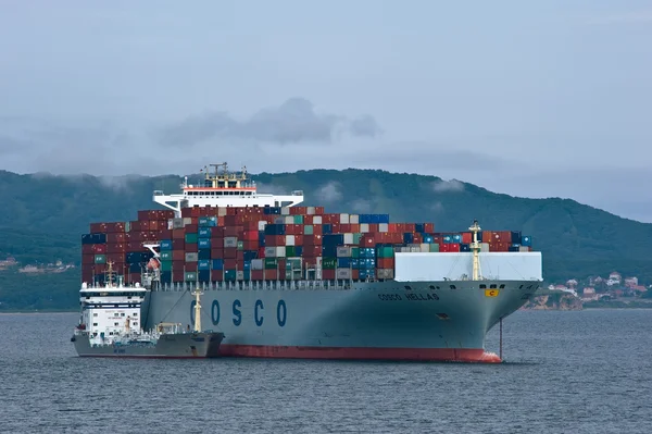 Nakhodka. Rússia - 18 de julho de 2016: Bunkering tanker Taurus um grande navio porta-contentores COSCO Hellas . — Fotografia de Stock