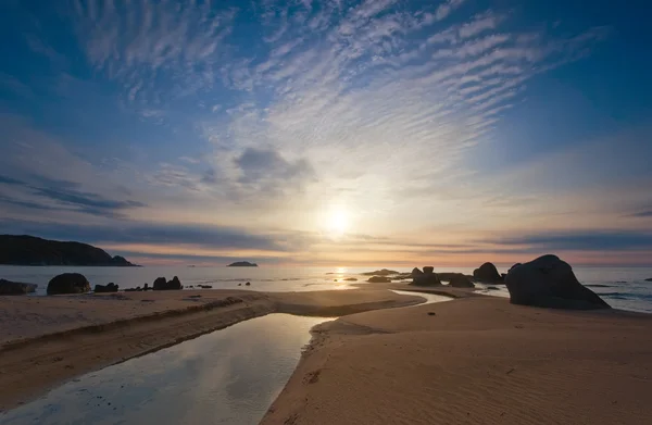 A boca de um pequeno riacho, que flui para o mar no início da manhã de verão . — Fotografia de Stock