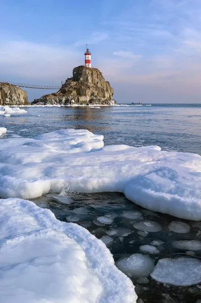 Winterbild Leuchtturm auf einem einsamen Felsen. östliches (japanisches) Meer. — Stockfoto